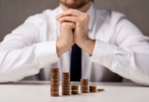 Госдолг Ростовской области вырос на треть за год и приблизился к 60 млрд рублей Монеты в виде графика перед бизнесменом //Фото Freepick