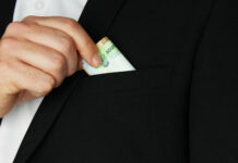 Ущерб от коррупции в Ростовской области составил 112 млн рублей в 2025 году Мужчина прячет деньги в карман //Фото Freepik, wirestock