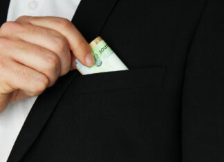 Ущерб от коррупции в Ростовской области составил 112 млн рублей в 2025 году Мужчина прячет деньги в карман //Фото Freepik, wirestock